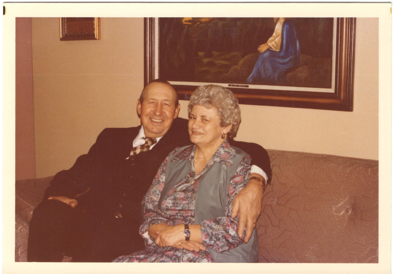 Man with arm around woman on couch
