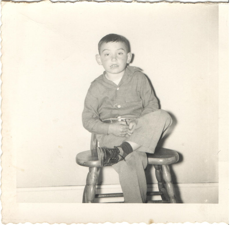 Young boy sitting on chair with legs crossed