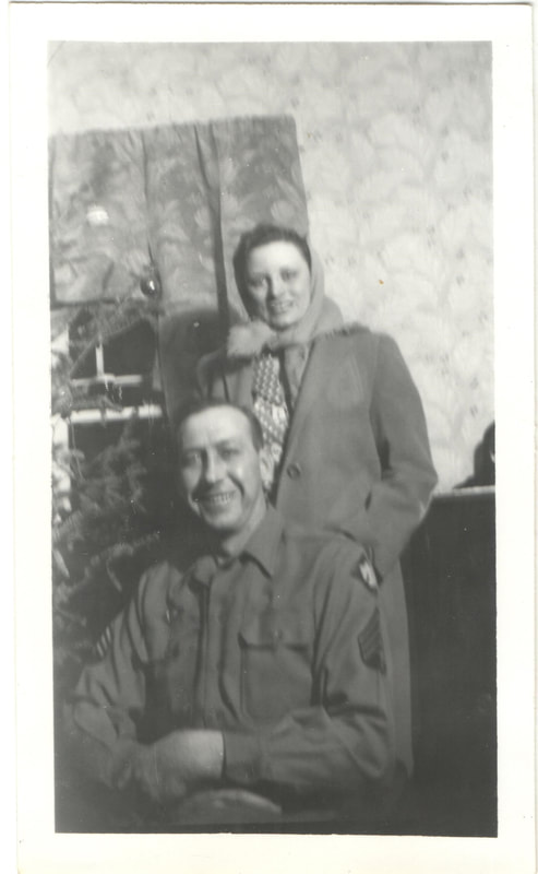Man in service uniform seated in front of woman standing
