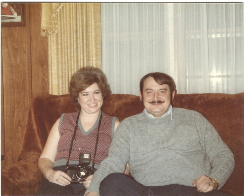 Man and woman with camera sitting on couch
