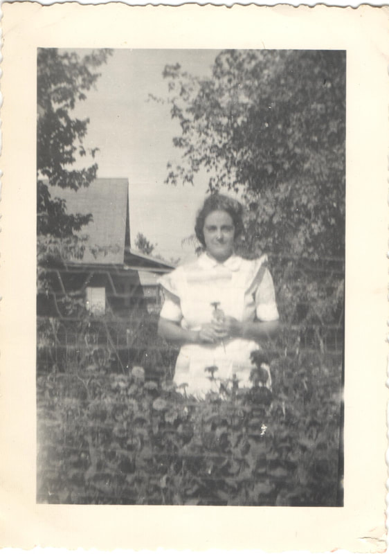 Woman standing in garden holding flower