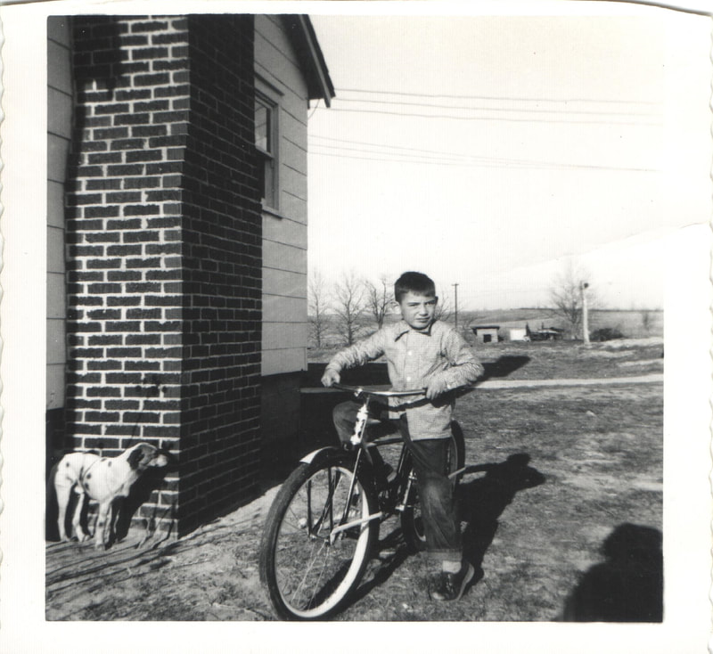 Young boy on bicycle next to building