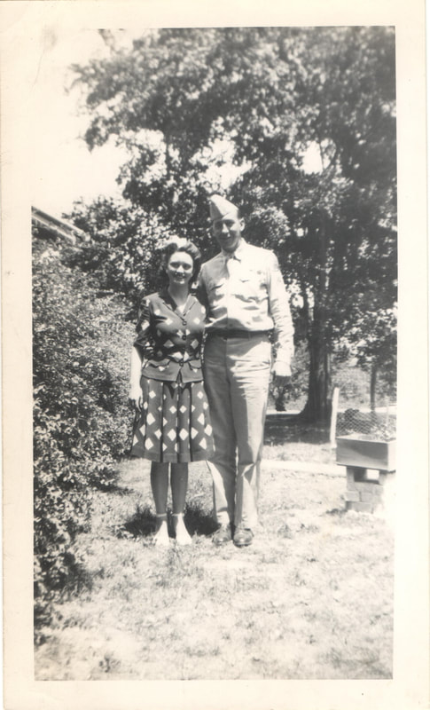 Soldier standing next to woman in yard