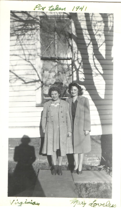 Women in overcoats standing in front of building