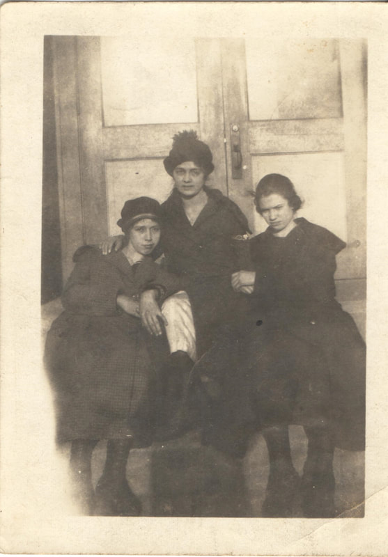 Women seated together in front of building