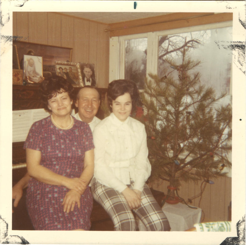Man and women seated together next to Christmas tree
