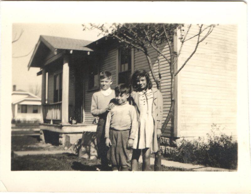Young boys and girl standing together in front of house