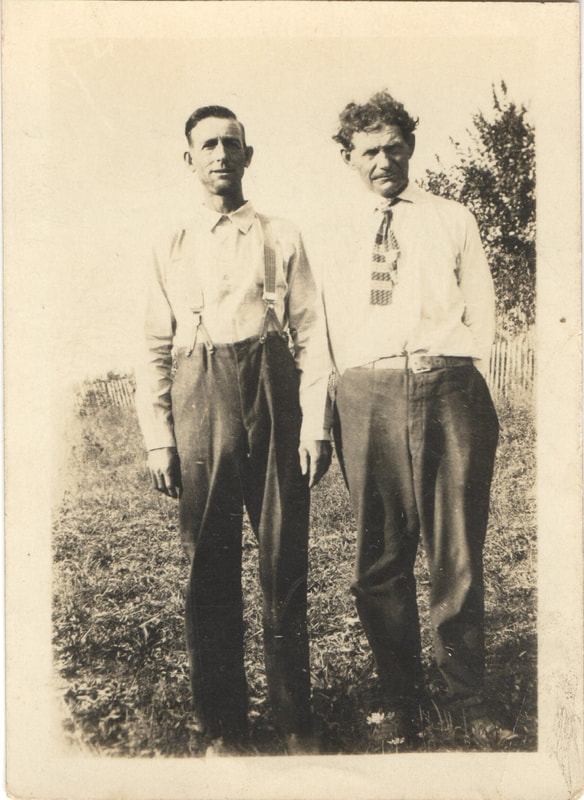 Man in tie standing next to man in suspenders 