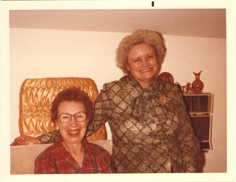Elderly woman standing next to elderly woman seated