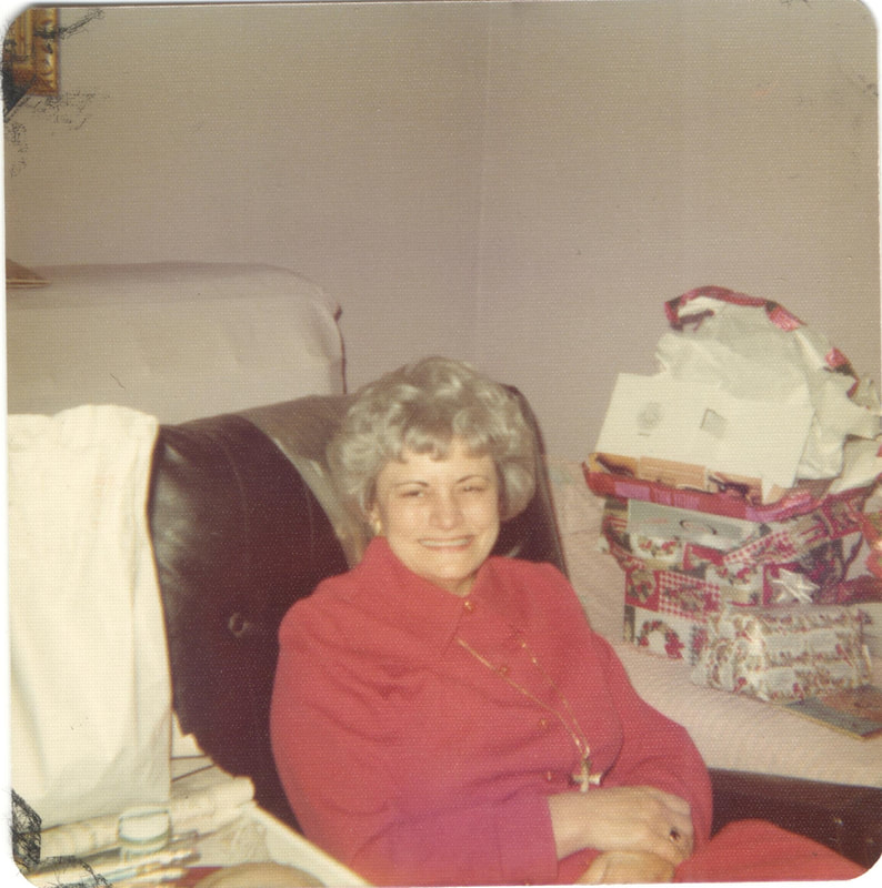 Elderly woman in cross necklace seated at Christmas gathering