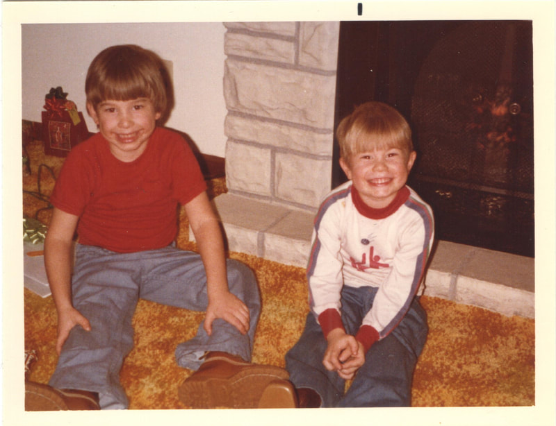 Young boys seated together in front of fireplace at Christmas gathering