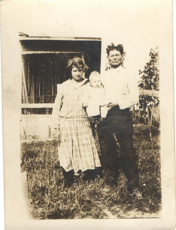 Man holding baby standing next to woman