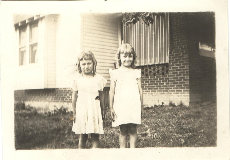 Young girls standing together in yard