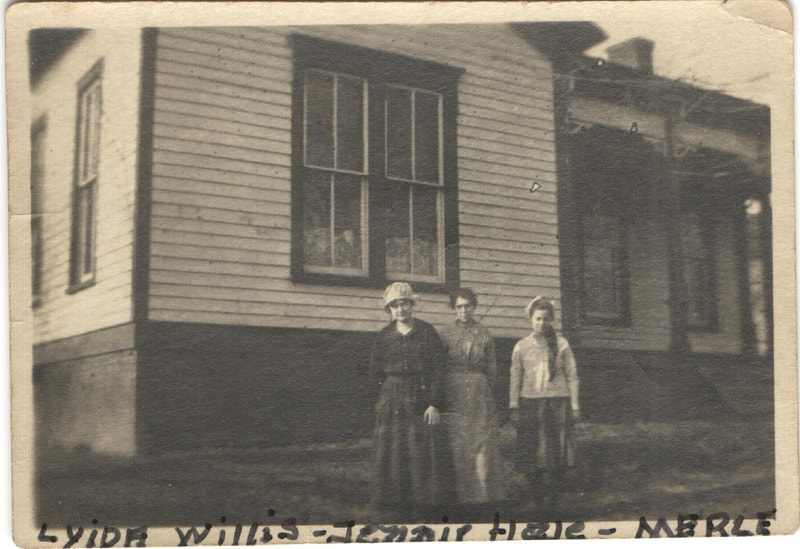 Women and young woman standing outside of home