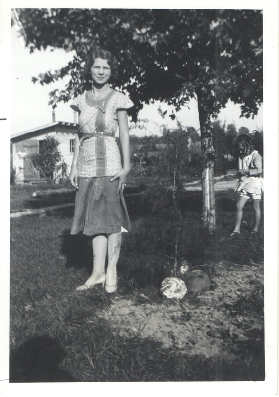 Young woman standing outside in front of young girl