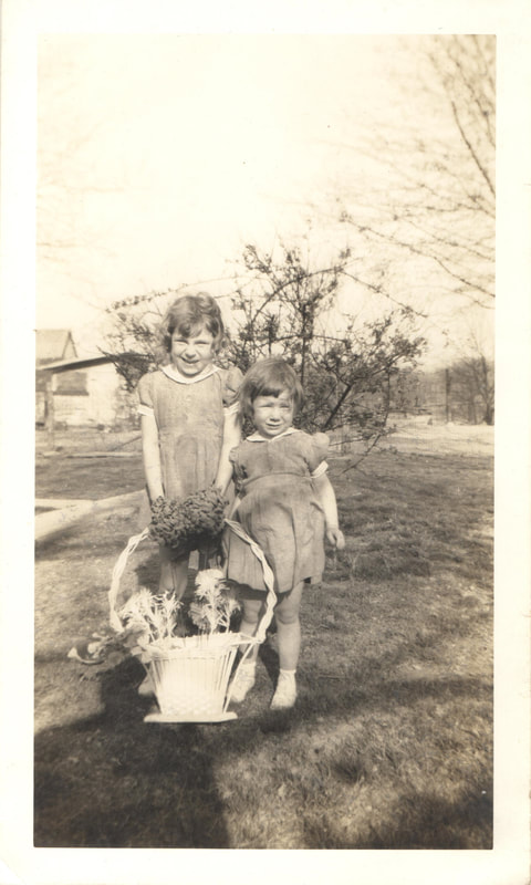 Young girls standing in front of flower basket
