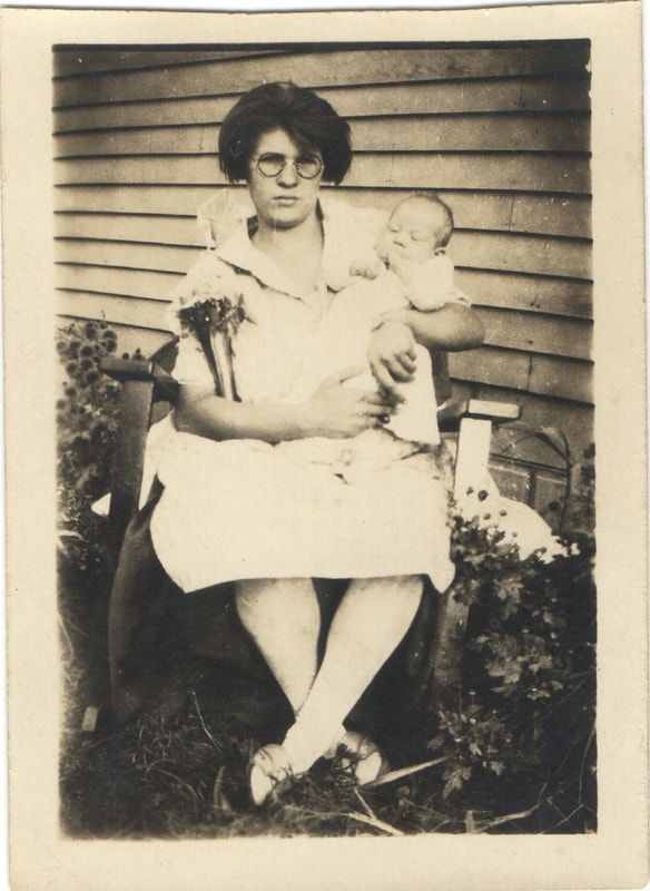 Woman in glasses seated with baby