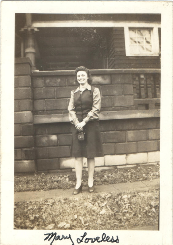 Young woman holding purse in front of house