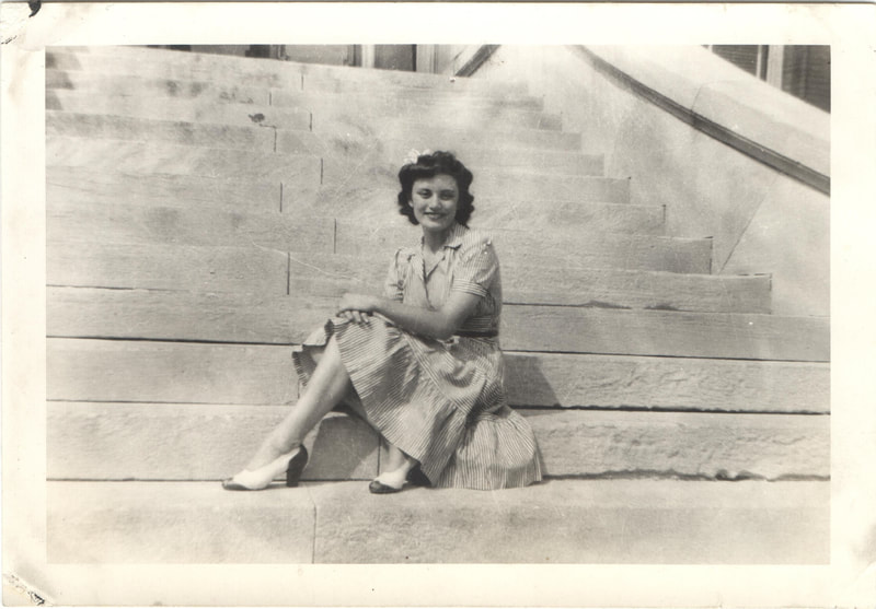 Young woman seated on stairs of building