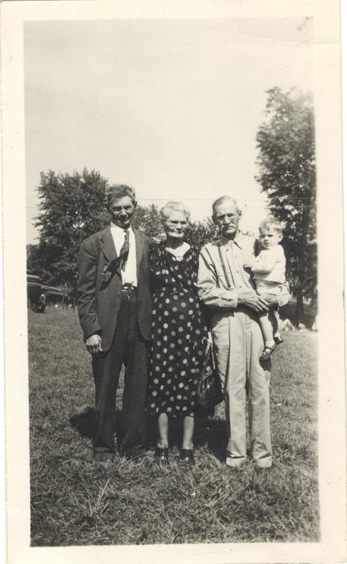 Elderly man holding baby next to elderly man and woman