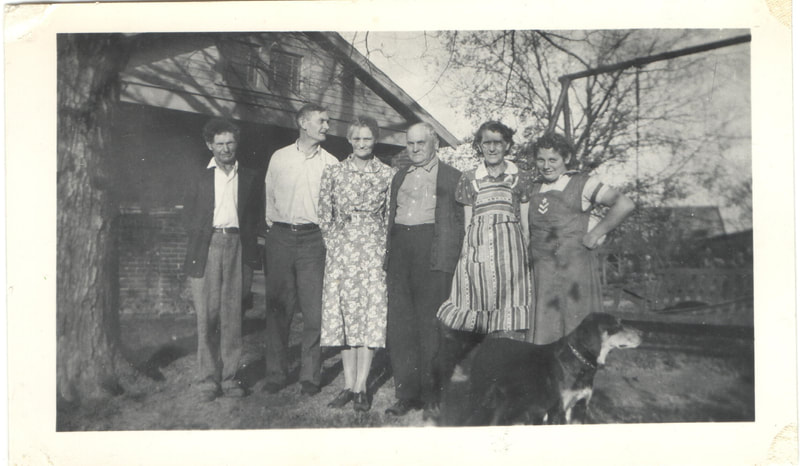Family standing in yard in front of dog