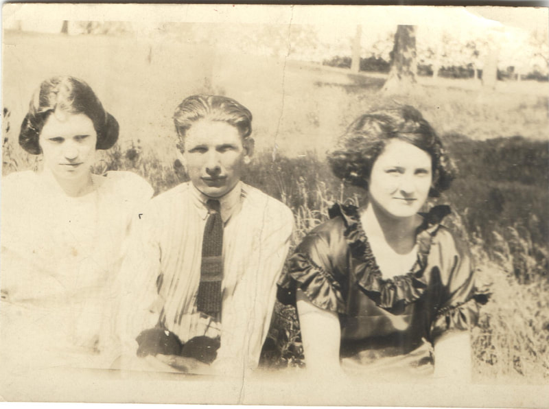 Young man seated between young women