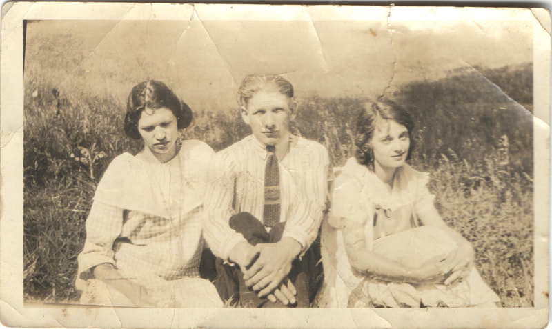 Young man in tie seated between girls