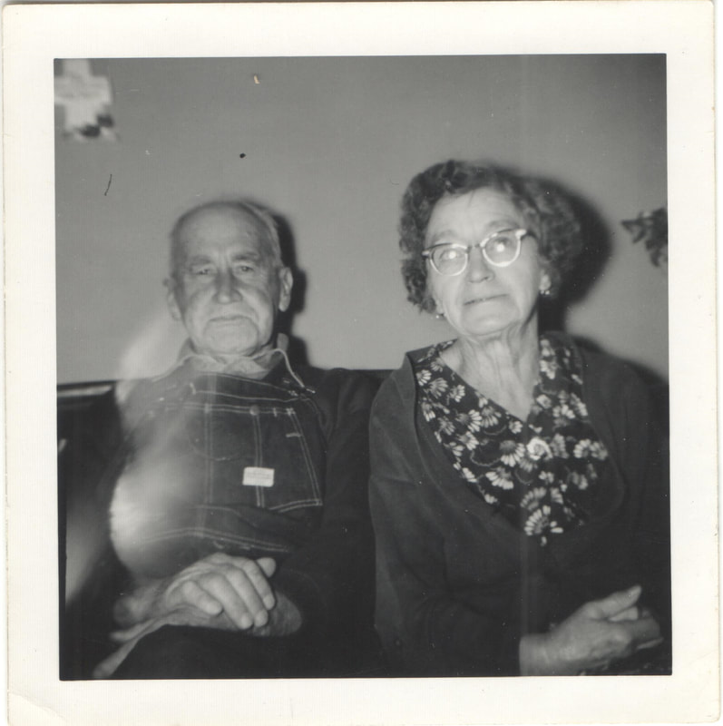 Elderly man and woman seated on couch