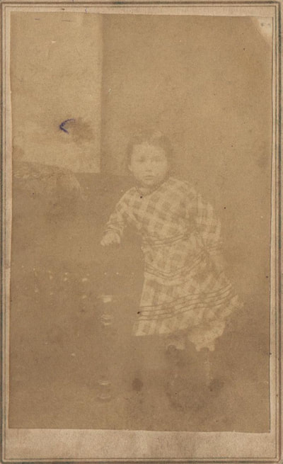 Young girl standing at chair in pattern dress