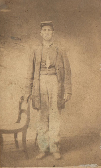 Young Man in soldiers uniform standing next to chair