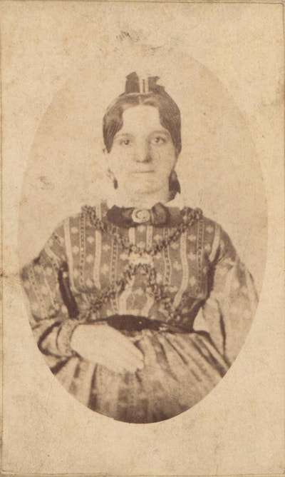 Woman standing with lips pursed in bowtie and dress