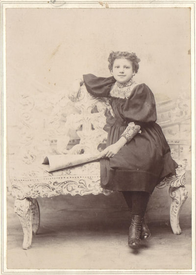 Young woman in dress seated at bench