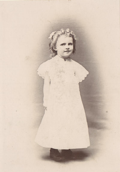 Young girl standing in white dress