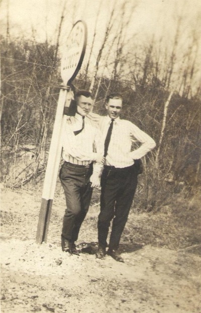 Men with ties standing together at sign