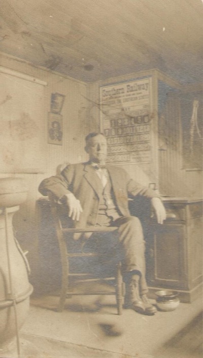 Man Seated at Desk Under Southern Railway Sign