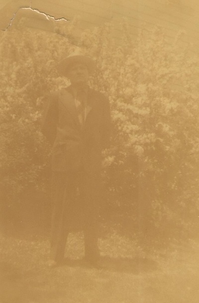 Man in hat standing in yard