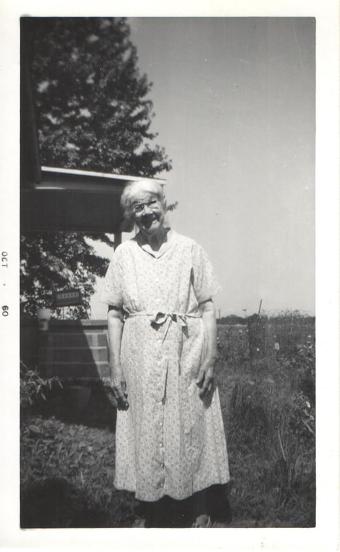 Elderly woman standing in yard