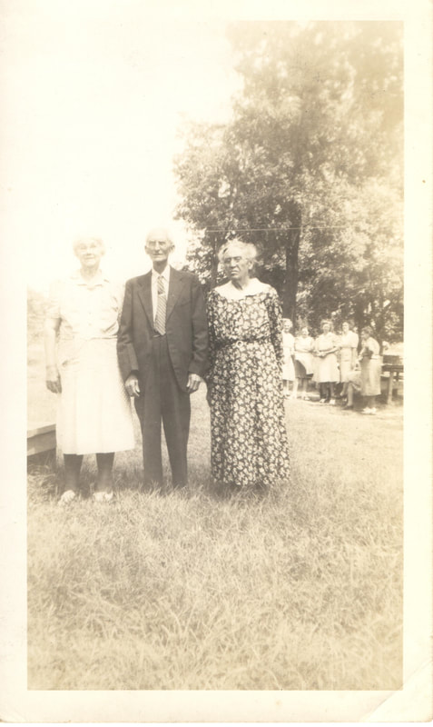 Elderly women and man standing near family gathering