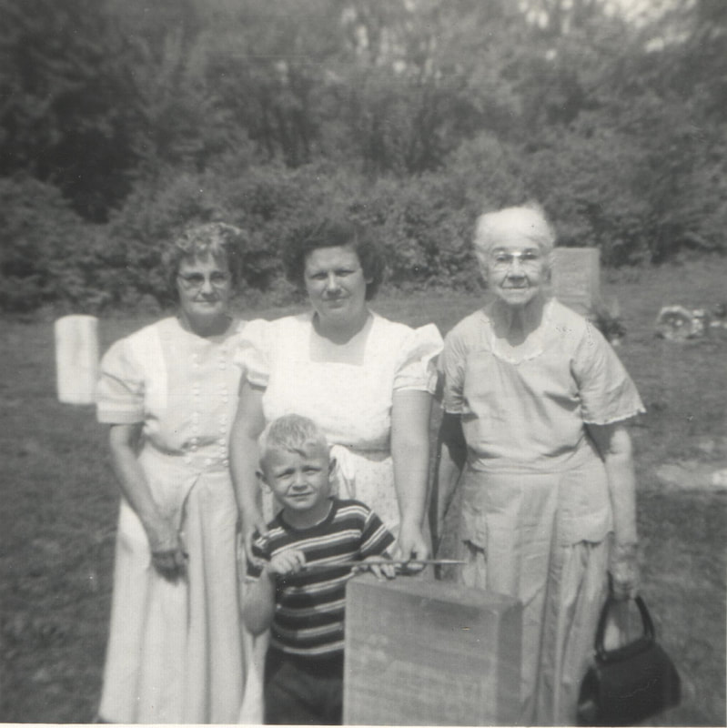 Women standing with young boy in cemetery