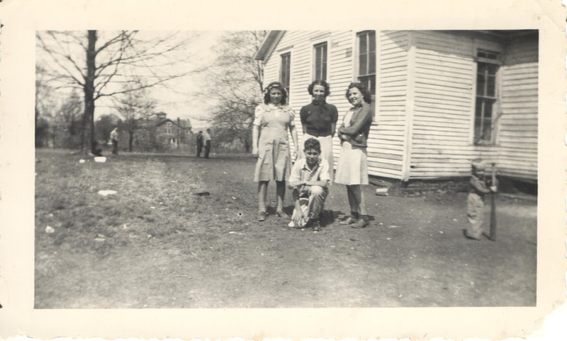 Young women and boy standing together near building
