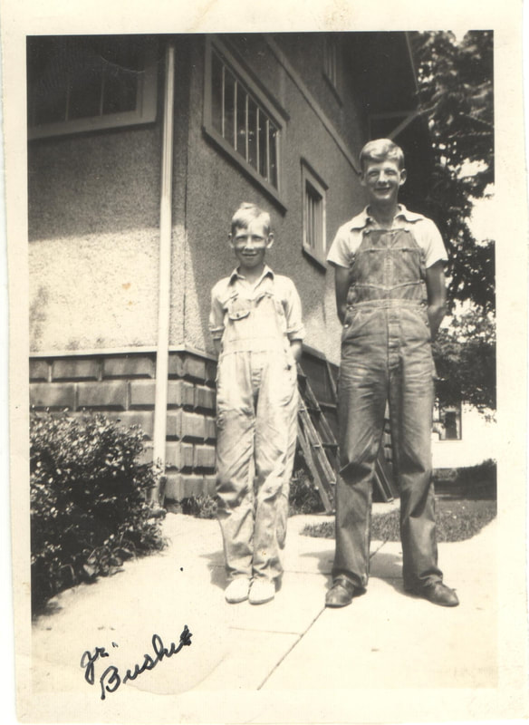 Young men in overalls standing in front of house