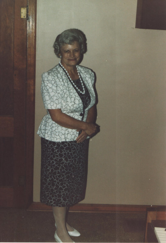 Elderly woman wearing necklace standing