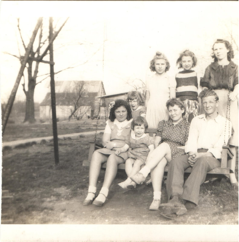 Young men and women gathered around swing in yard